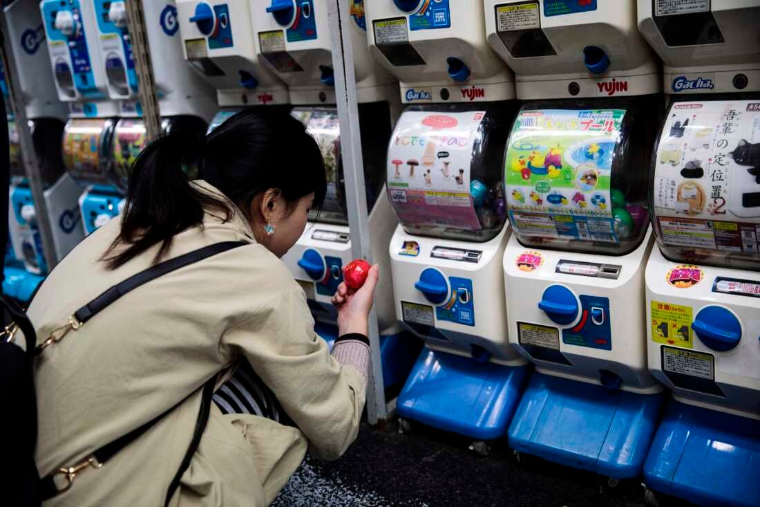 En esta fotografía tomada el 14 de noviembre de 2017, una mujer mira su artículo recién comprado en su búsqueda de juguetes cápsula en una tienda en el distrito Akihabara de Tokio.